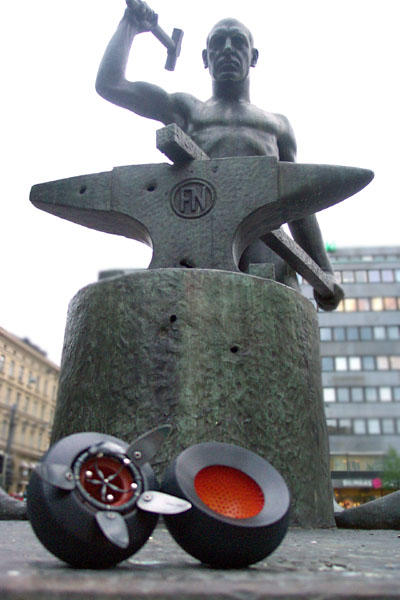 seed pod in front of a statue of a worker with hammer and anvil